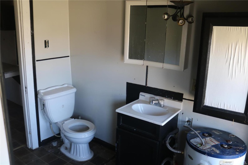 Upstairs Full Bathroom featuring toilet, vanity, and water heater