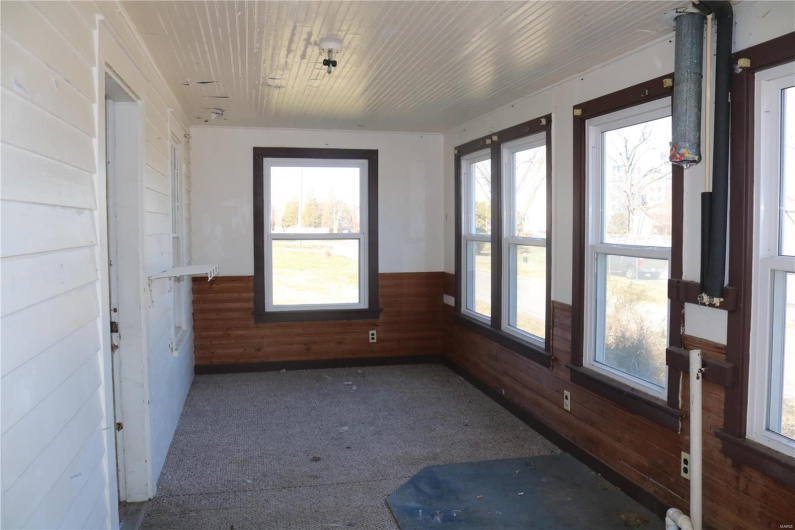 Unfurnished sunroom featuring wood ceiling and a healthy amount of sunlight