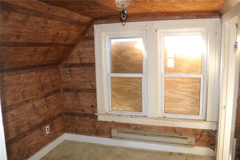 Upstairs Bedroom #2 featuring baseboard heating, wooden walls, and vaulted ceiling
