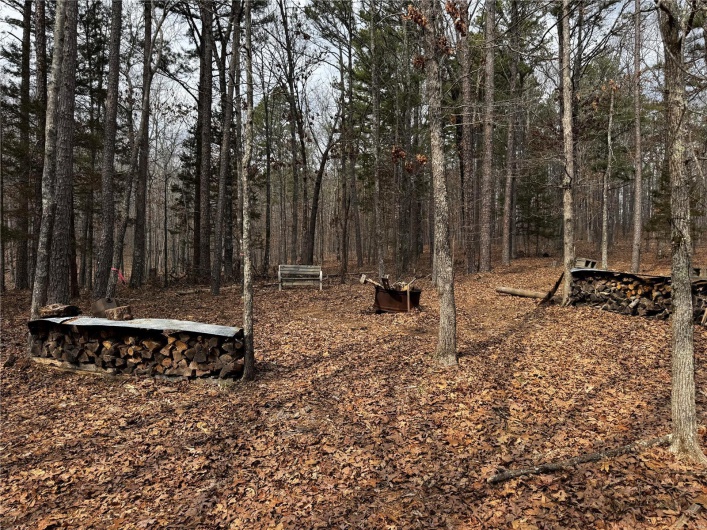 View of yard with a view of trees and an outdoor fire pit