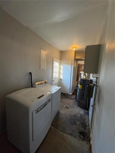 Washroom featuring washer and clothes dryer, electric panel, and water heater