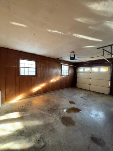 Garage featuring wood walls and a garage door opener