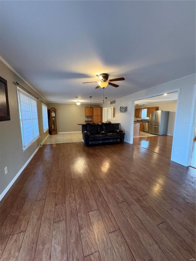 Unfurnished living room with ceiling fan and hardwood / wood-style floors