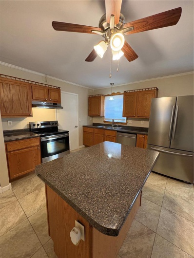 Kitchen with a center island, refrigerator, stove, ventilation hood, and dishwashing machine