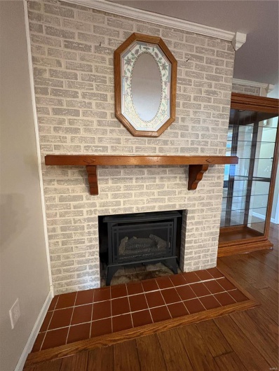 Interior details with ornamental molding, hardwood / wood-style floors, and a fireplace