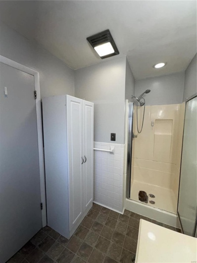 Bathroom with a shower and tile walls