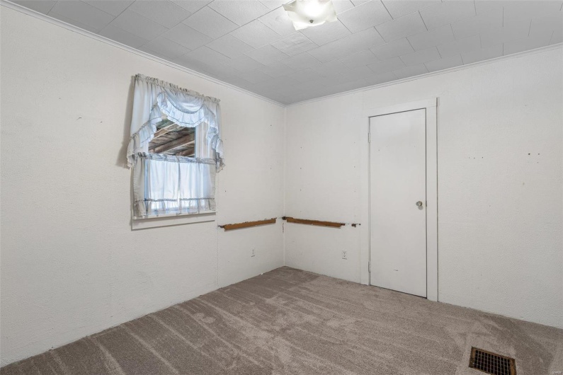 Carpeted spare room featuring visible vents