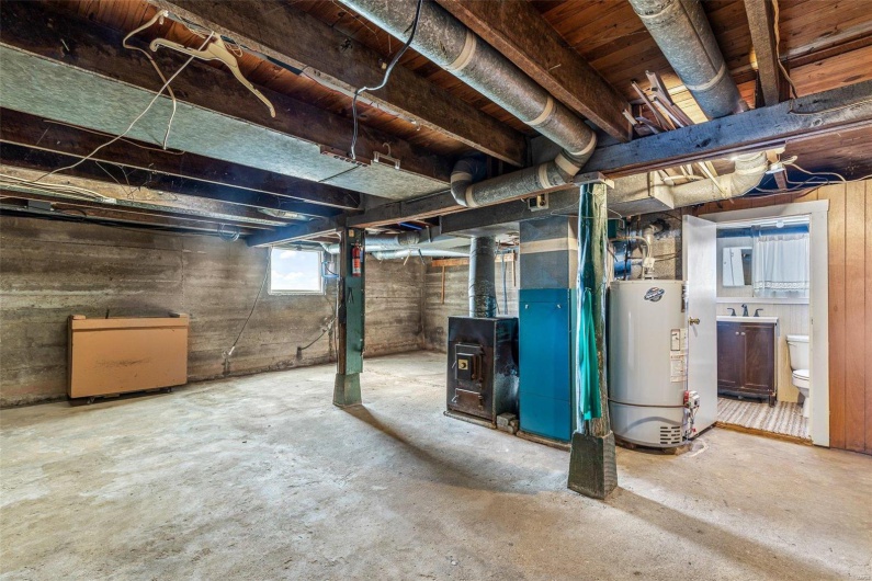 Basement with heating unit, gas water heater, and a sink