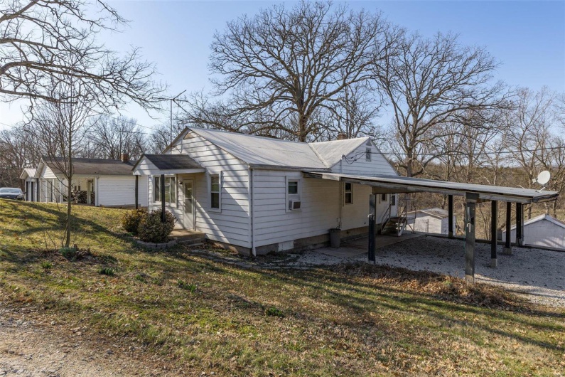 View of home's exterior featuring a carport, a yard, and crawl space