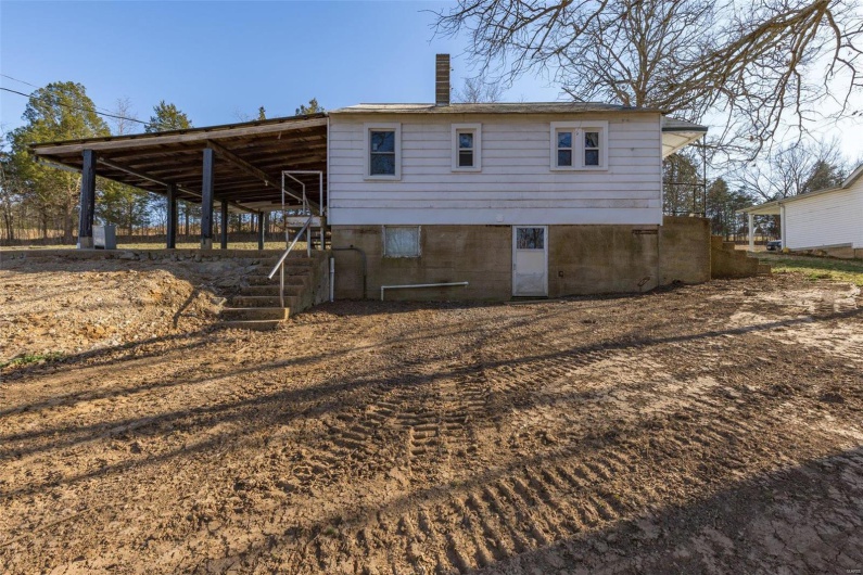 Rear view of house featuring an outbuilding and a chimney