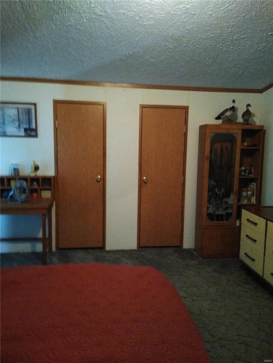 Carpeted bedroom featuring a textured ceiling and crown molding
