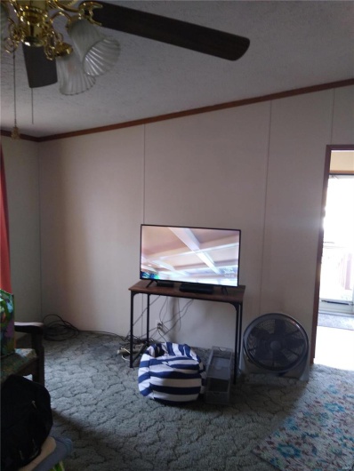 Living room featuring ornamental molding and carpet floors