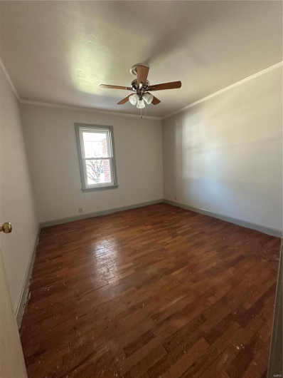 Empty room featuring baseboards, crown molding, a ceiling fan, and wood-type flooring