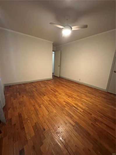 Unfurnished room with baseboards, a ceiling fan, and wood-type flooring