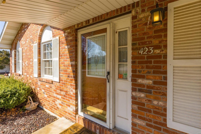 Property entrance with a porch and brick siding