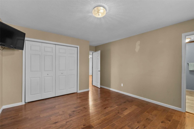 Unfurnished bedroom with a closet, baseboards, and wood finished floors