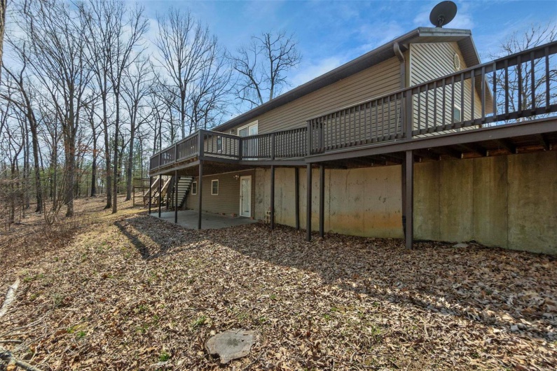 Back of property featuring stairs, a patio area, and a wooden deck
