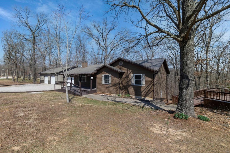 View of front facade with a front lawn, a garage, driveway, and a chimney