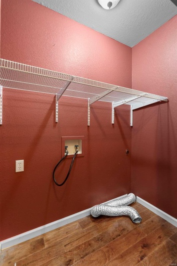 Laundry area featuring laundry area, hookup for a washing machine, baseboards, and hardwood / wood-style flooring