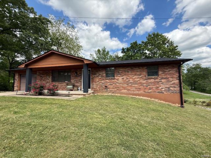 Ranch-style home with a garage, brick siding, and a front yard
