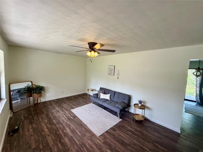 Living area featuring a ceiling fan, wood finished floors, and baseboards