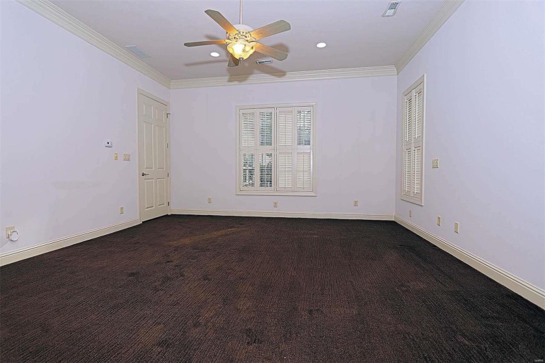 Carpeted spare room featuring crown molding and ceiling fan