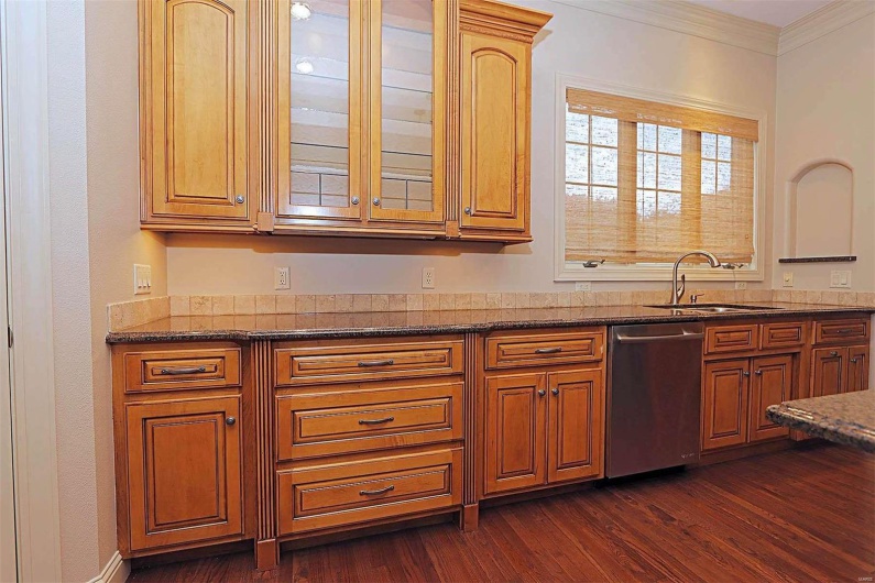 Kitchen with ornamental molding, dishwasher, sink, and dark wood-type flooring