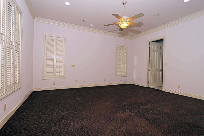 Carpeted empty room featuring crown molding and ceiling fan
