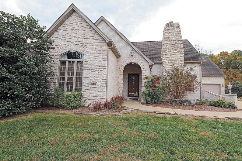 View of front of property with a front yard and a garage