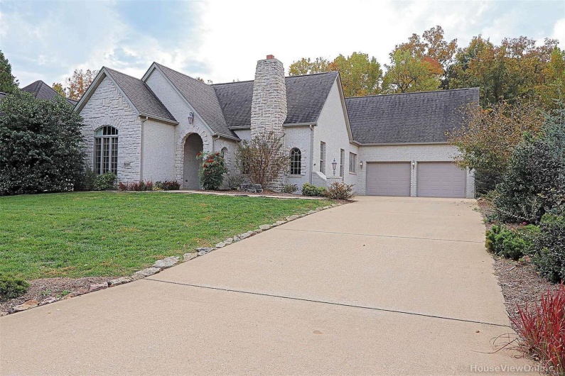 French country style house with a front yard and a garage