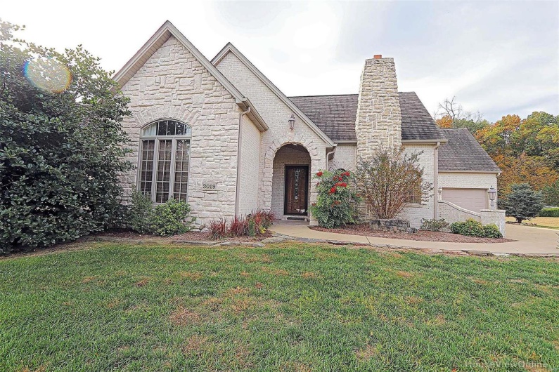 French country home with a front lawn and a garage