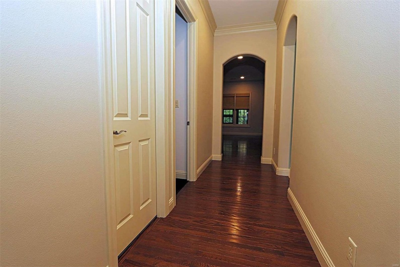 Hallway featuring ornamental molding and dark hardwood / wood-style flooring