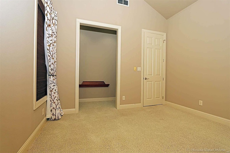 Unfurnished bedroom featuring vaulted ceiling and carpet flooring