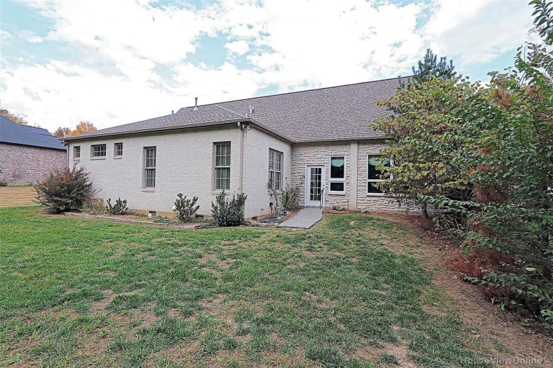 Back of property with a lawn