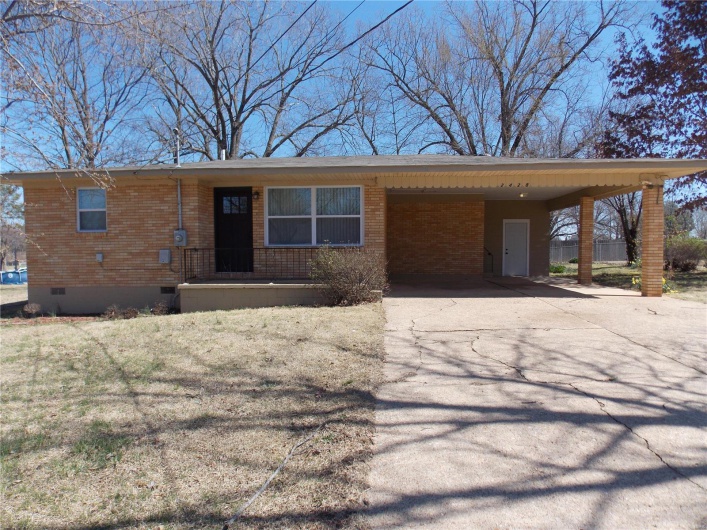 Ranch-style house with a carport, brick siding, driveway, and crawl space