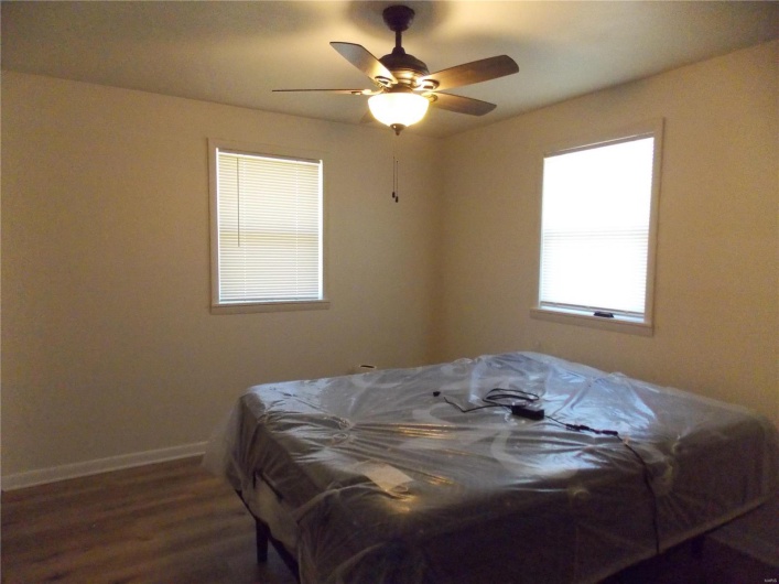 Bedroom featuring ceiling fan, baseboards, and wood finished floors