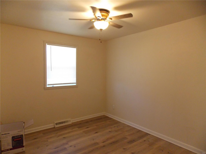 Empty room featuring visible vents, baseboards, light wood-type flooring, and ceiling fan