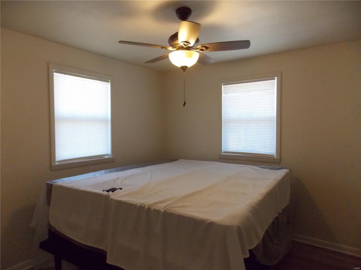 Bedroom with multiple windows and a ceiling fan
