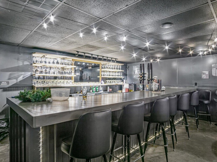 Bar featuring a paneled ceiling and concrete flooring