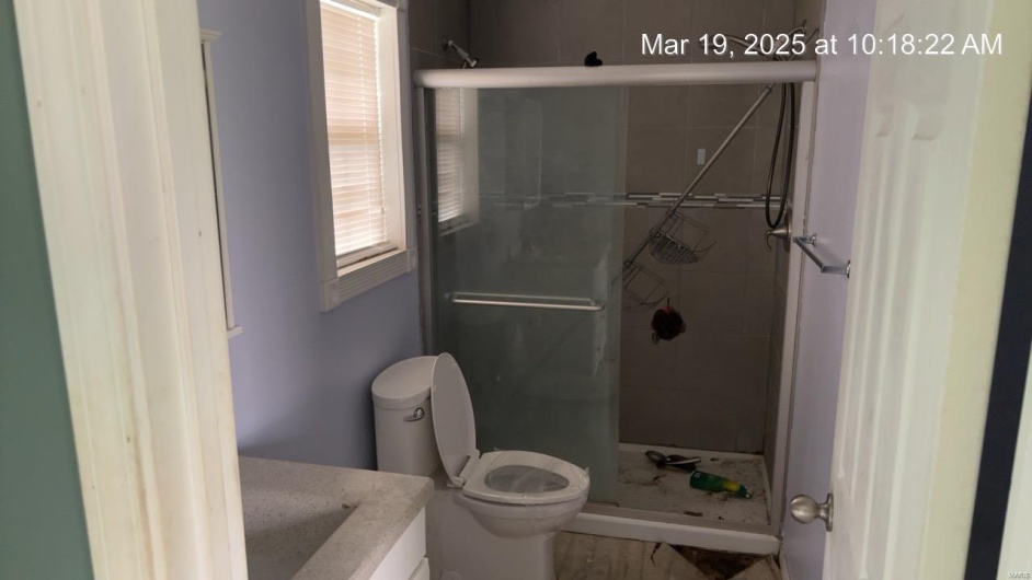 Bathroom featuring toilet, a stall shower, and vanity