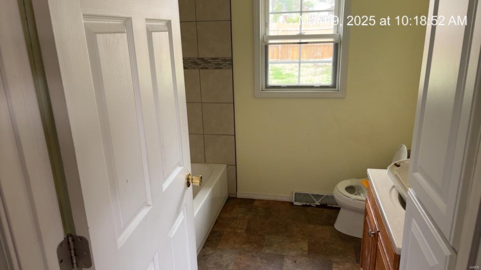 Full bathroom featuring vanity, baseboards, visible vents, stone finish floor, and toilet