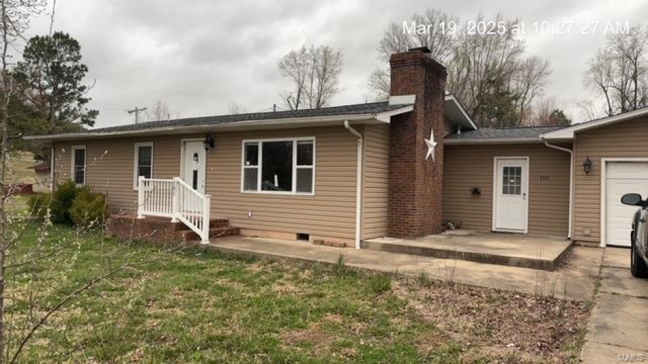 View of front of property featuring a front yard, a chimney, a garage, crawl space, and a patio