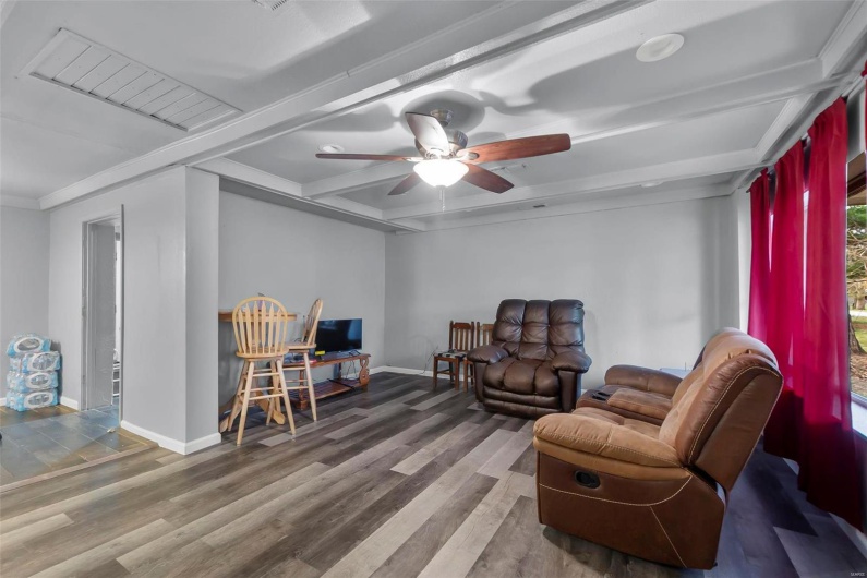 Sitting room with beamed ceiling, a ceiling fan, baseboards, and wood finished floors