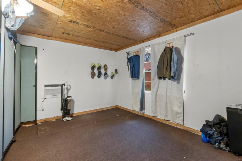 Carpeted spare room with baseboards and a wall unit AC