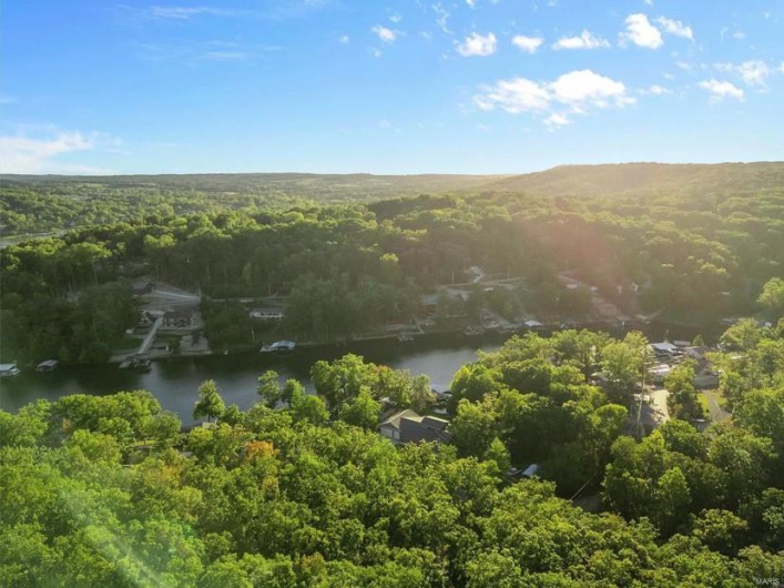 Birds eye view of property featuring a view of trees and a water view
