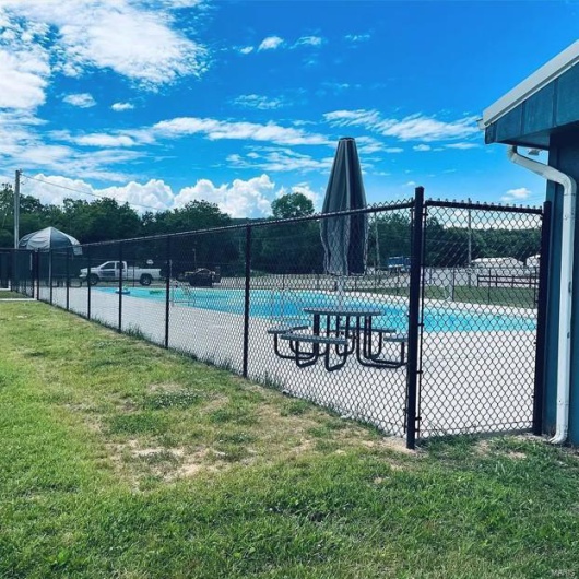 Community pool featuring a yard and fence