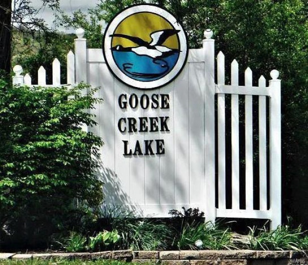 Community / neighborhood sign featuring fence