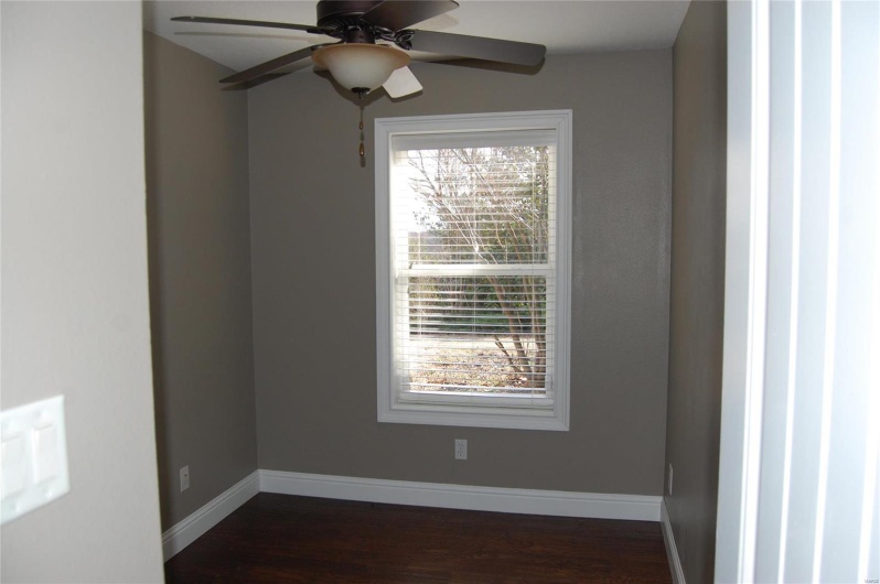 Spare room with baseboards, dark wood-style flooring, and ceiling fan