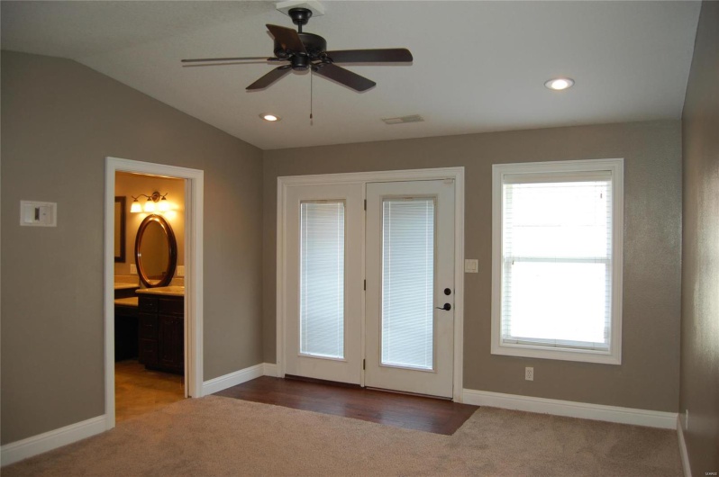 Entryway featuring visible vents, lofted ceiling, baseboards, and carpet flooring