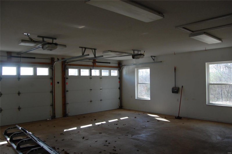 Garage featuring a garage door opener and baseboards